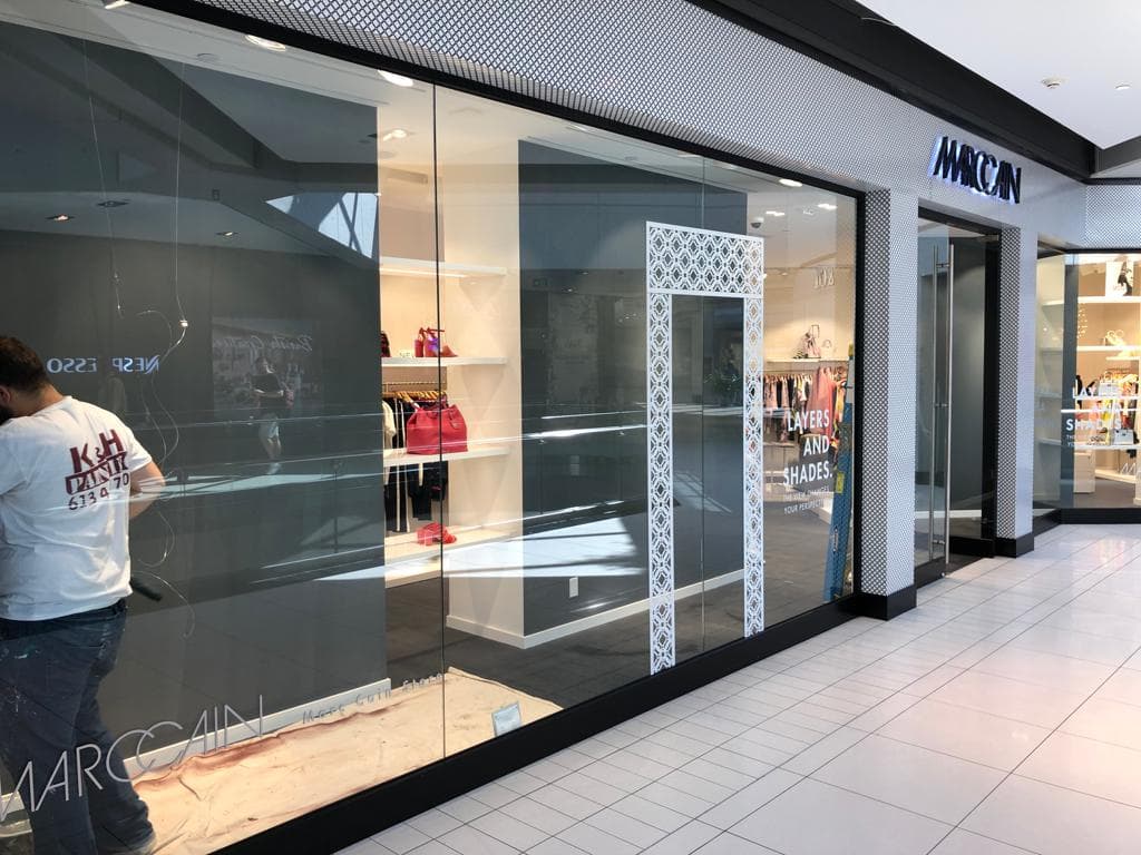 K&H painter refinishing a retail storefront inside a shopping mall